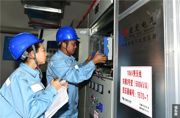 “火车头”田维维与同事紧密协作，正在安顺新天地东苑小区二号配电房内安装电能计量装置，把好计量关口，保障客户用电。（刘高才摄） 