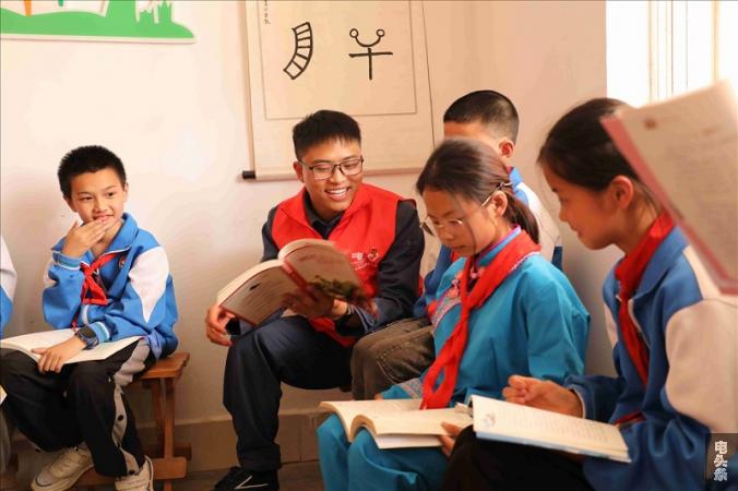 南方电网云南曲靖富源供电局青年志愿者在古敢小学和孩子们共同阅读、畅谈理想。方宇摄