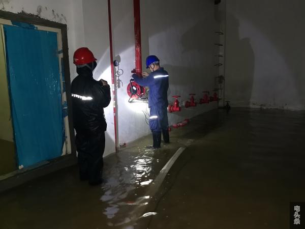 抢修人员对地下室配电房进行排水