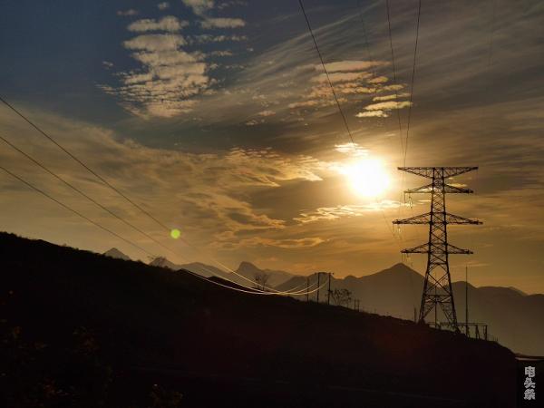 夕阳照耀下光伏电站旁的电塔和线路