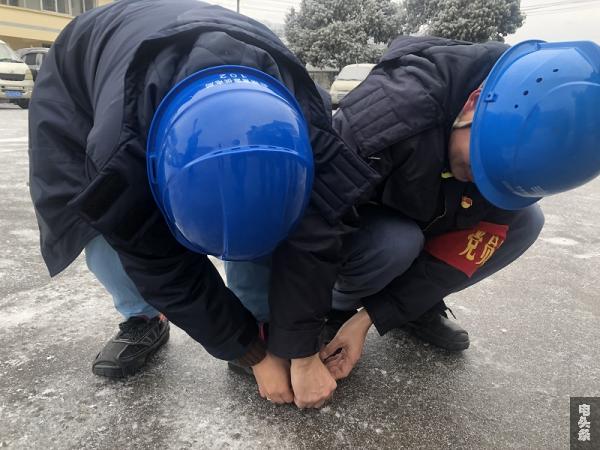 巡线前，党员监督岗师傅帮助女职工穿戴防滑脚扣